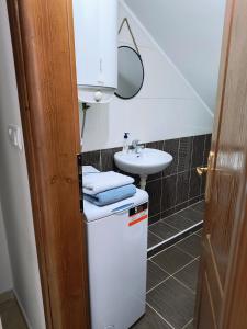 a small bathroom with a sink and a refrigerator at ATTICA APARTMENTS in Bijelo Polje
