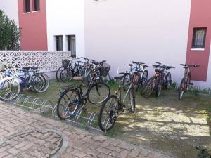 eine Gruppe von Fahrrädern, die neben einem Gebäude geparkt werden in der Unterkunft T2 - Les pieds dans le sables en toutes saisons 5 couchages - climatisation - parking privée - piscine - situation optimum et rare - Amoureva - Plage Richelieu- Cap d'Agde in Cap d'Agde