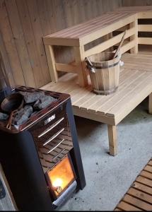 a grill sitting next to a wooden bench with a table at Hytte ved Preikestolen in Forsand