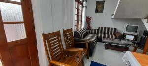 een woonkamer met een bank en een tv bij Sahasna Guest House in Diyatalawa