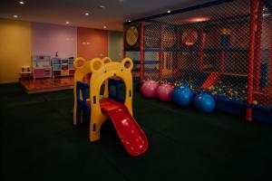 un parque infantil con un tobogán rojo en una habitación en Chris Park Hotel, en Campos do Jordão