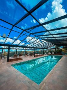 a large swimming pool under a roof with a view of the ocean at Chris Park Hotel in Campos do Jordão