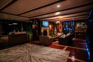 a living room with couches and a bar at Chris Park Hotel in Campos do Jordão