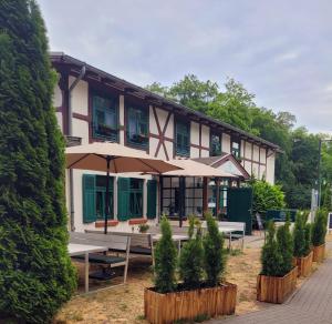 a building with picnic tables in front of it at Pension Am Stadtholz in Kröpelin