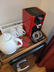a coffee maker and cups on top of a refrigerator at Pension Am Stadtholz in Kröpelin