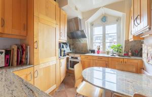 ヌイイ・シュル・セーヌにあるNice Apartment In Neuilly-Sur-Seineのキッチン(木製キャビネット、テーブル、窓付)