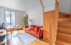 ヌイイ・シュル・セーヌにあるNice Apartment In Neuilly-Sur-Seineのリビングルーム(赤いソファ、階段付)