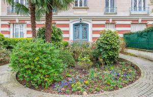 ヌイイ・シュル・セーヌにあるNice Apartment In Neuilly-Sur-Seineの花の庭が目の前にある家 +14枚の写真