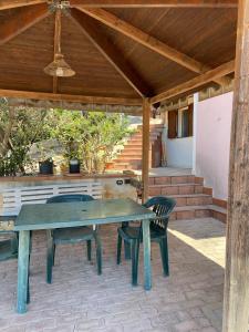een picknicktafel en 2 stoelen op een patio bij Villa Gazebo Panoramico in Licata