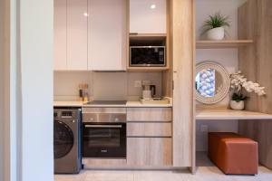 une cuisine avec des armoires blanches et une cuisinière dans l'établissement Zimbali Boulevard Suites Apartments, à Ballito