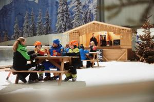 un grupo de personas sentadas en una mesa de picnic en la nieve en Hotel Hamburg-Wittenburg van der Valk en Wittenburg