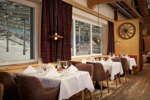 a dining room with tables and chairs and a clock at Hotel Hamburg-Wittenburg van der Valk in Wittenburg