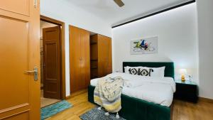 una camera da letto con un letto con testiera verde di BluO Vasant Vihar PVR - Kitchen, Terrace, Lift a Nuova Delhi