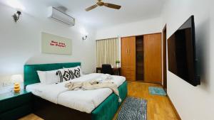 a bedroom with a bed with a green headboard at BluO Vasant Vihar PVR - Kitchen, Terrace, Lift in New Delhi