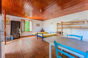 sala de estar con mesa y sillas azules en La halte de Compostelle, en Belin-Beliet