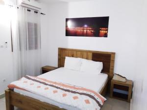 a bedroom with a bed and a tv on the wall at Keur Mina in Saint-Louis