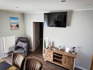 a living room with a tv on the wall at Ferienwohnung Vogt in Blankenburg +10 photos