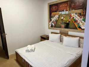 a bedroom with a bed with a painting on the wall at Hotel Afsona old city in Bukhara
