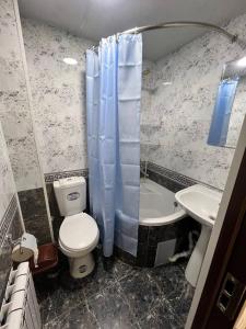 a bathroom with a toilet and a sink and a tub at Hotel Afsona old city in Bukhara