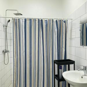 La salle de bains est pourvue d'un rideau de douche et d'un lavabo. dans l'établissement Charly Arconville i, à Abomey-Calavi