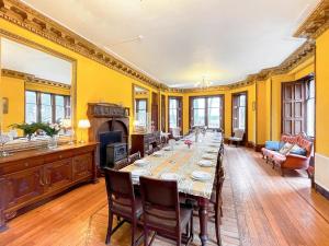 a dining room with a long table and a fireplace at Harvieston Hall in Gorebridge