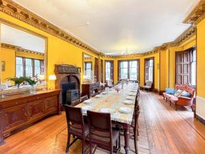 un comedor con una mesa larga y una chimenea en Harvieston Hall en Gorebridge