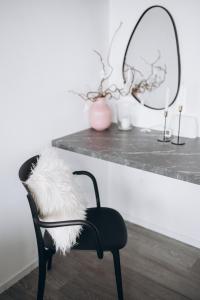 a black chair with a white furry seat and a mirror at 7 SKY UDINE in Udine