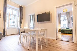 a dining room with a table and chairs and a tv at Metropolitan Charm: Stylish 2+1 Apt@ Vienna's Core in Vienna
