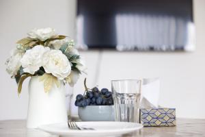 a table with a vase of flowers and a glass at Wonderful Holiday Studio in the Trendy Brick Lane in London