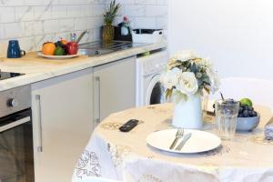 a kitchen with a table with a vase of flowers at Wonderful Holiday Studio in the Trendy Brick Lane in London