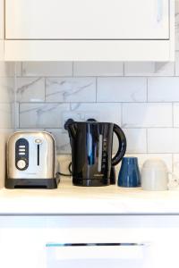 a black coffee pot and a toaster on a kitchen counter at Wonderful Holiday Studio in the Trendy Brick Lane in London