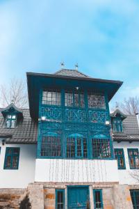 ein Gebäude mit blauen Fenstern und einem Dach in der Unterkunft Casa Plaiul Cailor: Rustic Mountain Hideaway in Proviţa de Sus