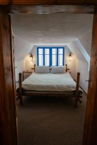 ein Schlafzimmer mit einem großen Bett mit einem blauen Fenster in der Unterkunft Casa Plaiul Cailor: Rustic Mountain Hideaway in Proviţa de Sus