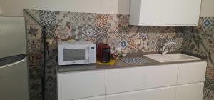a kitchen counter with a microwave and a sink at Al Cortile Tranquillo in Cascina