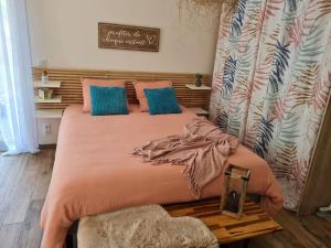 a bedroom with a large bed with blue and pink pillows at Gîte à la campagne proche de toutes commodités. in Pernes-lès-Boulogne