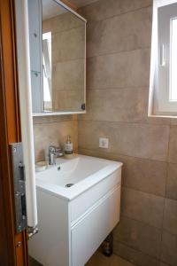 ein Badezimmer mit einem weißen Waschbecken und einem Spiegel in der Unterkunft Casa Plaiul Cailor: Rustic Mountain Hideaway in Proviţa de Sus