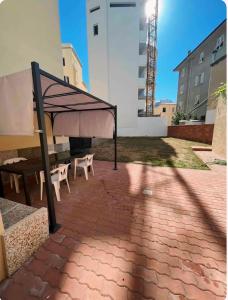 un padiglione con tavolo e panche su un patio in mattoni di Thomas' House ad Alghero