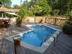 - une piscine sur une terrasse en bois avec une table et des chaises dans l'établissement Espace, calme, confort, à Saint-Michel-Escalus