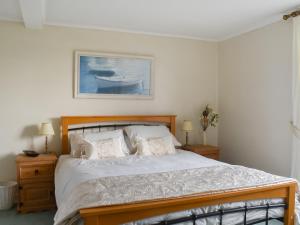 a bedroom with a bed and a picture of a boat at Findley Cottage 
