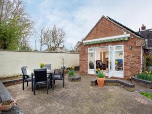 a patio with a table and chairs in front of a house at The Sowy in Bridgwater