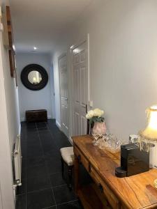 a room with a desk with a vase of flowers on it at Cosy 2 Double Bed Apartment in Swords