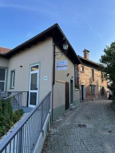 un edificio con una valla al lado de una calle en Locanda della Rocca di Camagna, en Camagna Monferrato