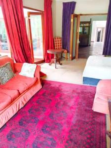 een woonkamer met een rode bank en een rood tapijt bij 50 Arklow in Johannesburg