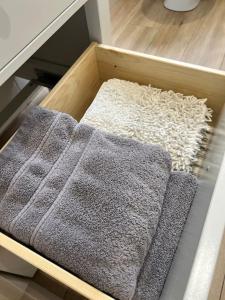 a wooden tray with three towels in a drawer at Cosy 2 Double Bed Apartment in Swords