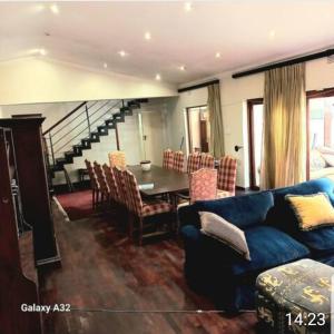 een woonkamer met een blauwe bank en een tafel bij 50 Arklow in Johannesburg