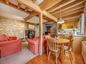 een keuken en een woonkamer met een tafel en stoelen bij Capp Mill in Painswick