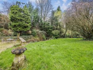 een tuin met een rots in het gras bij Capp Mill in Painswick