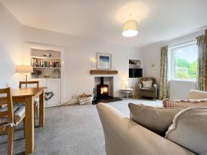 uma sala de estar com um sofá e uma lareira em Southbank Cottage em Errol