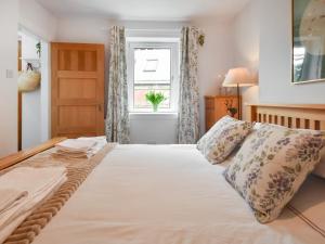 Un dormitorio con una cama grande y una ventana en Southbank Cottage, en Errol