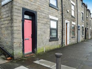 a red door on the side of a brick building at The Bolthole in Bolton